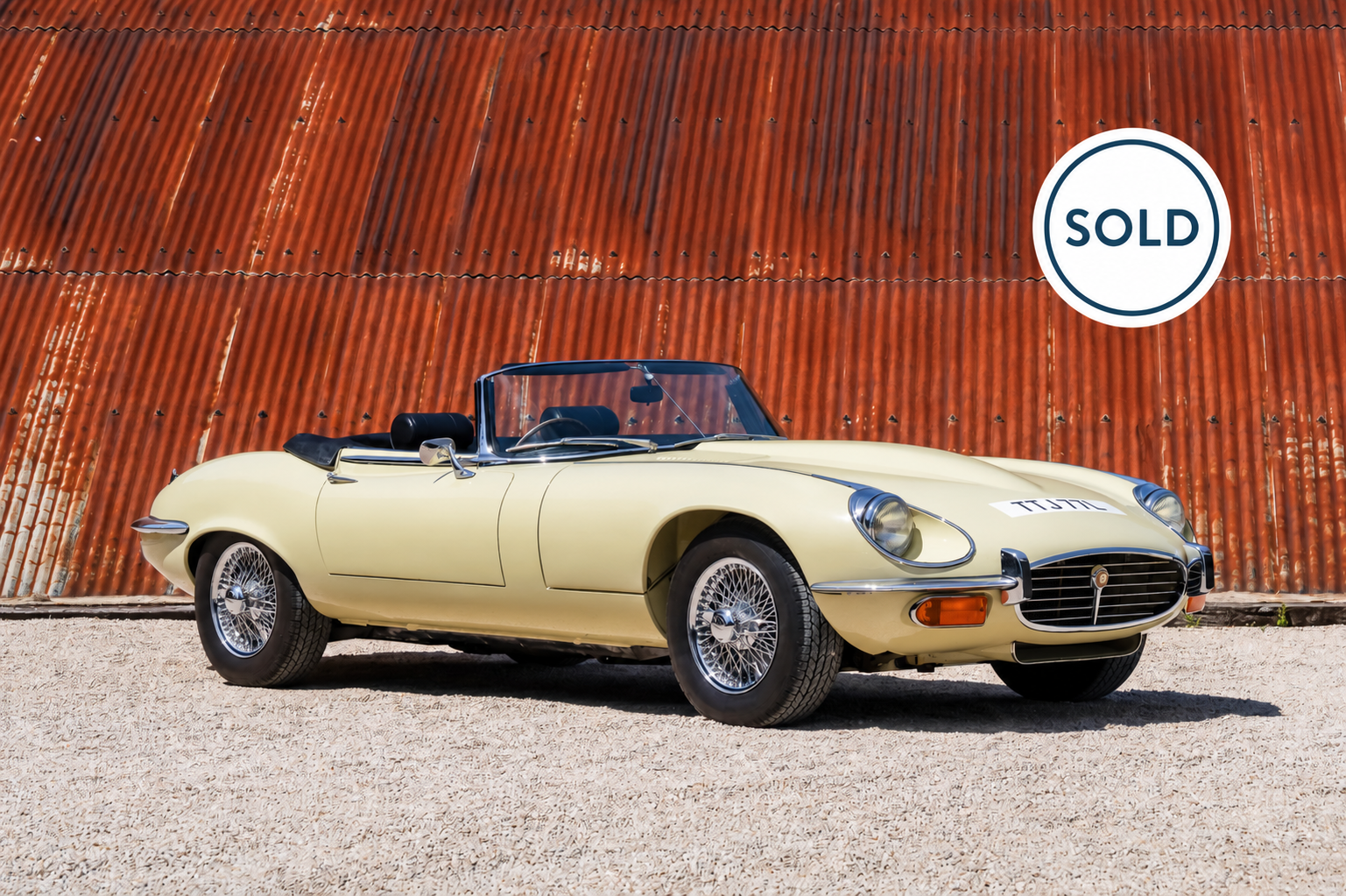 Cream Jaguar E-Type with sold badge